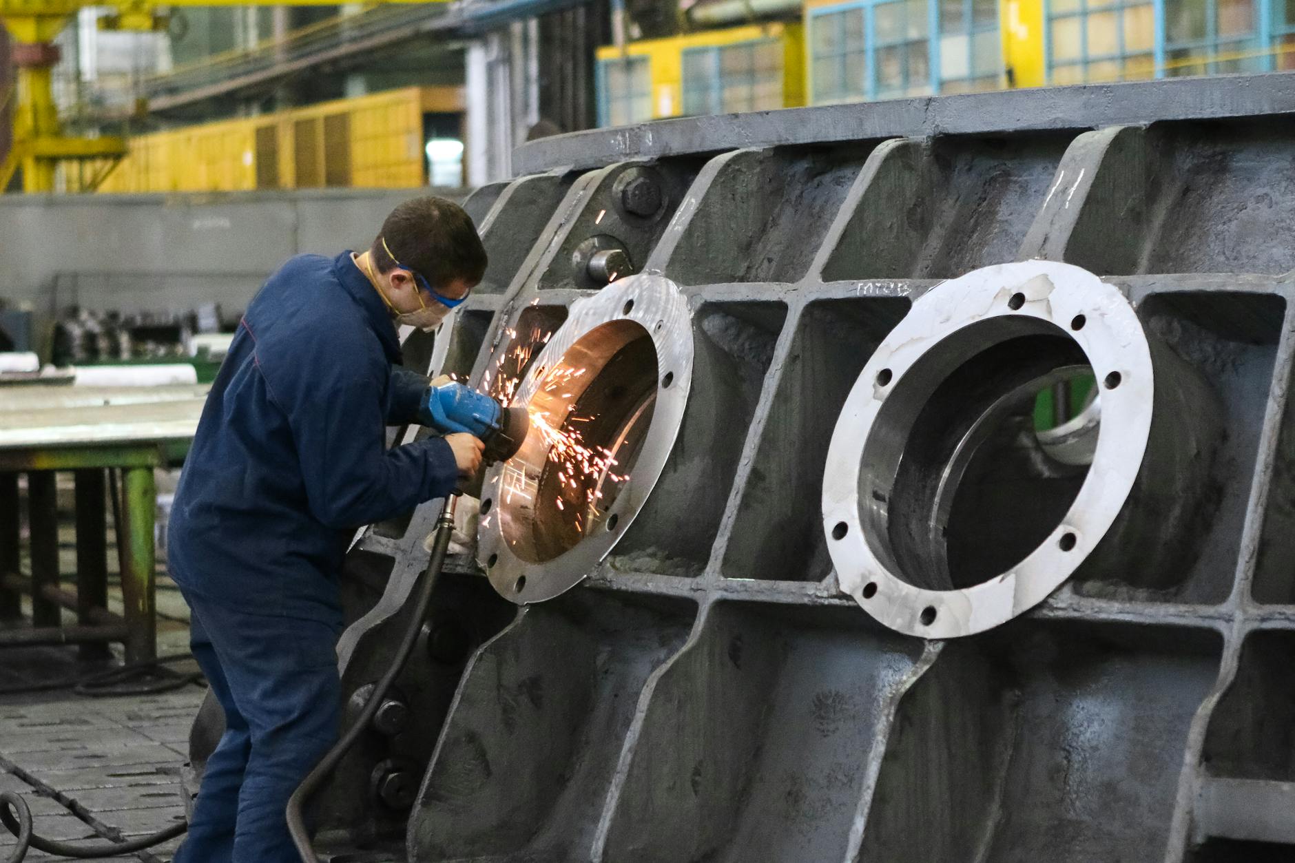 man welding round window frame