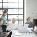 multiracial coworkers of different ages brainstorming together in office