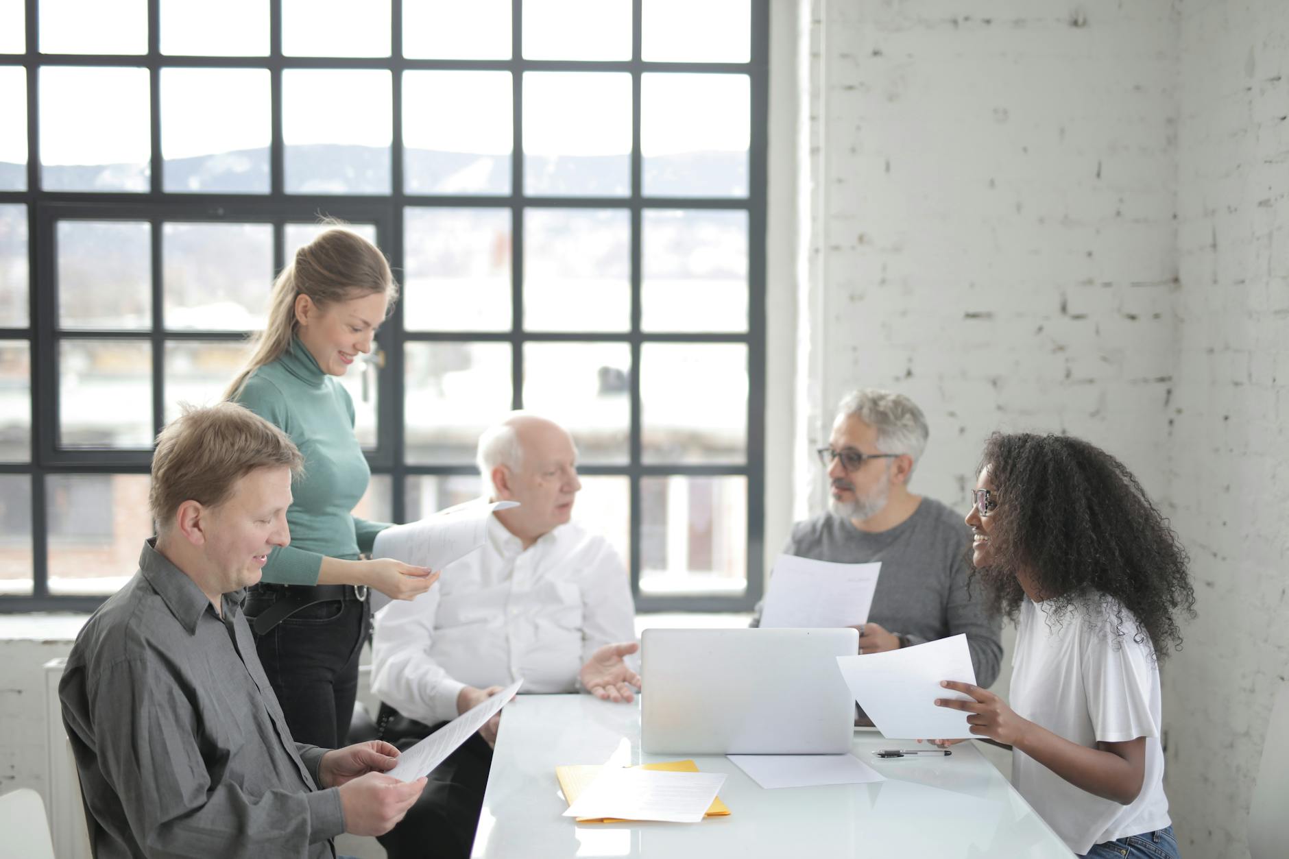 multiracial coworkers of different ages brainstorming together in office