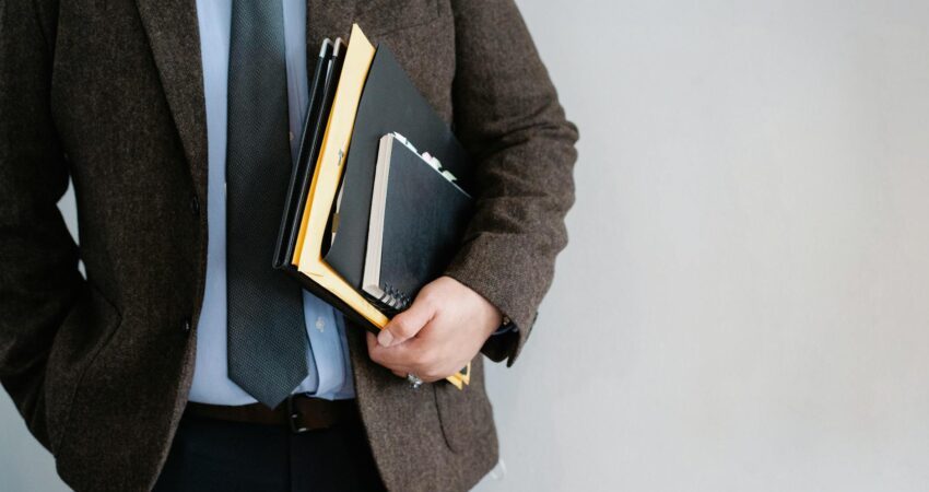 crop unrecognizable office worker standing with papers in hand