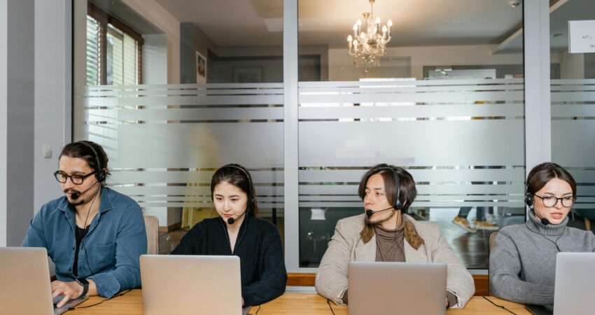 multiracial employees sitting in front of silver laptops