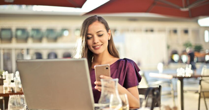 woman wearing purple shirt holding smartphone white sitting on chair