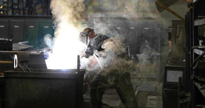 man wearing welding mask covered in welding smokes