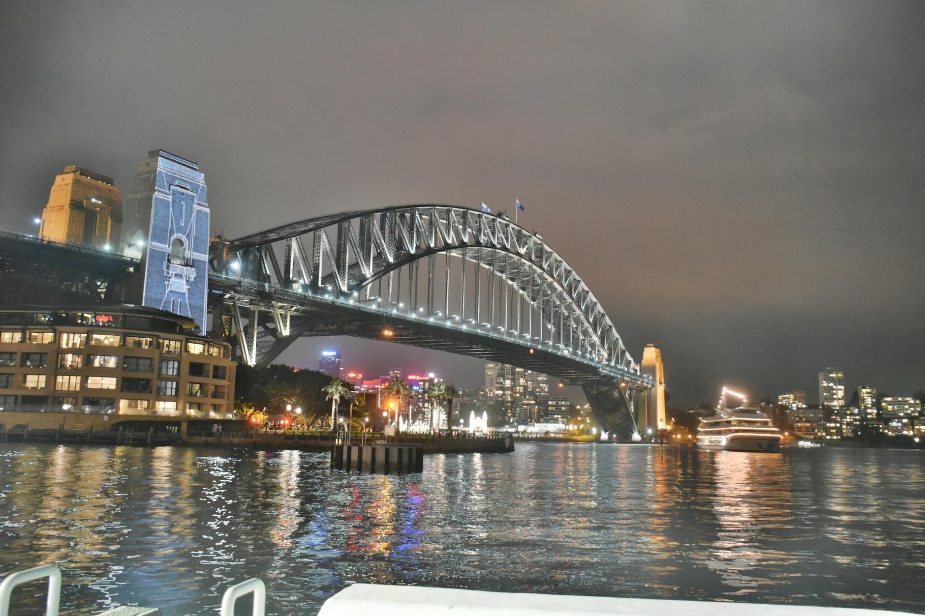 bridge under grey cloudy sky during nighttime