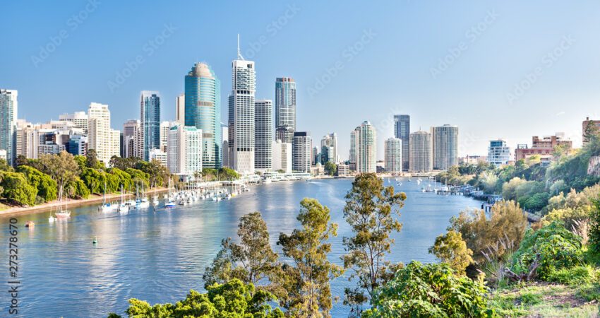 Blue water river surrounded by trees beside a modern city