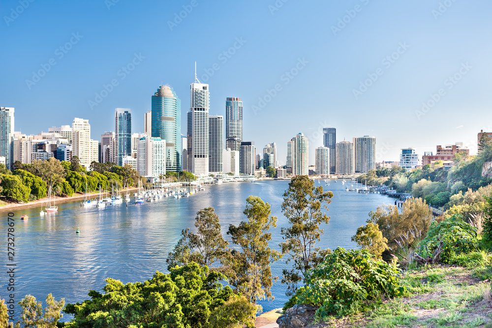 Blue water river surrounded by trees beside a modern city