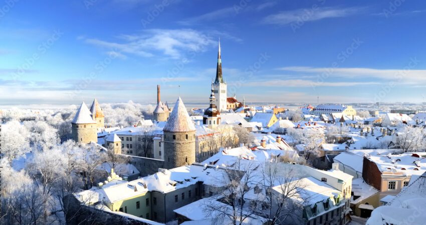 Panoramic aerial view of the old town of Tallinn, Estonia. St. Olaf's Church, fortress towers, snow-covered roofs and spires. Winter, Christmas vacations, travel destinations, sightseeing, culture